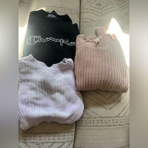One champion crew neck, purple tie up sweater, and pink oversized sweater.